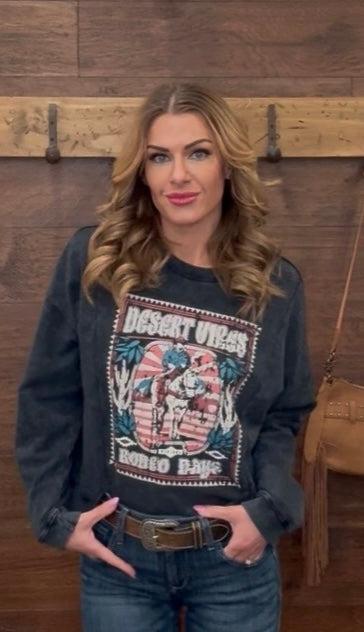 Woman wearing a graphic sweatshirt with a wooden wall background