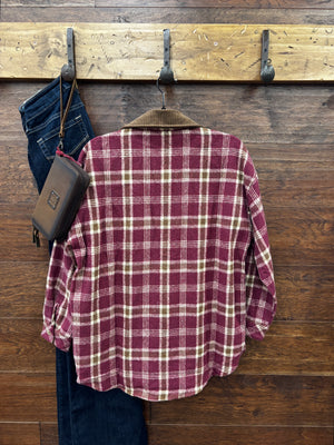 A burgundy and beige plaid flannel shirt with a brown corduroy collar and chest pockets