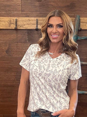 Woman wearing a floral blouse standing against a wooden background