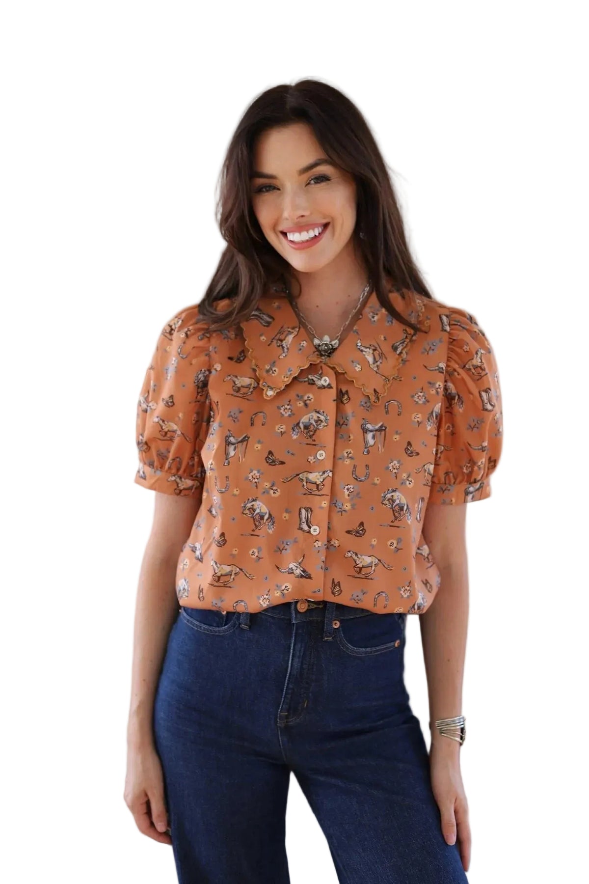 This vibrant, patterned short-sleeve shirt features an eye-catching design. The bold orange base is adorned with a playful mix of saddles, butterflies, and horses, creating a whimsical and charming piece. Perfect for adding a touch of fun and personality to any outfit.
