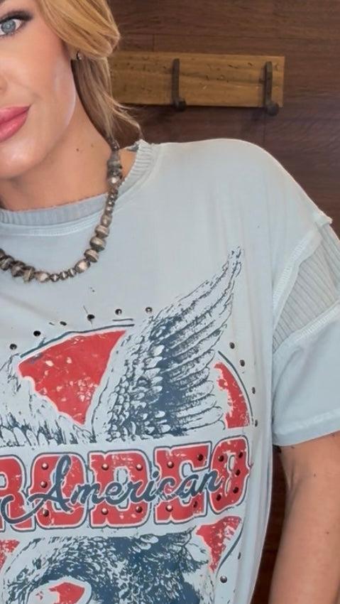 Person wearing a t-shirt with an eagle design and 'American' text.