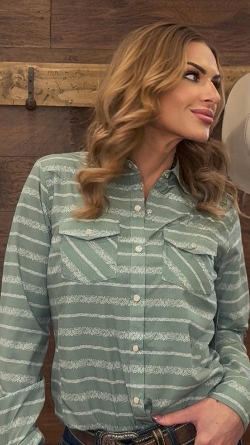 Woman wearing a green striped shirt with a wooden background