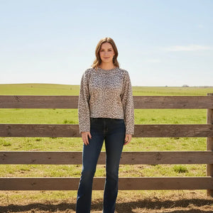 A woman wearing a beige and brown cheetah print knit sweater.