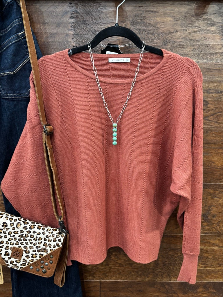 This sweater features a refined vertical texture, long dolman sleeves, and a classic boat neckline