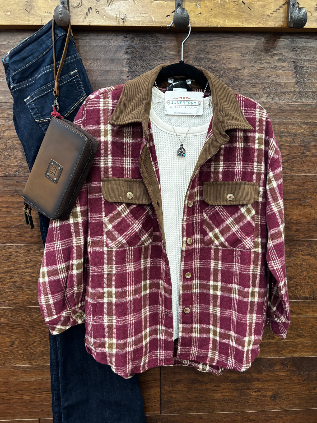 A burgundy and beige plaid flannel shirt with a brown corduroy collar and chest pockets