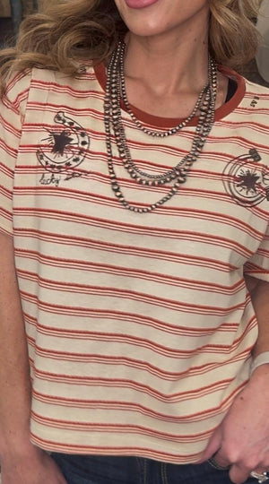 Person wearing a striped shirt with a logo and layered necklaces.