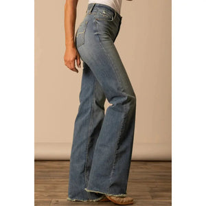 Person wearing blue jeans on a plain background
