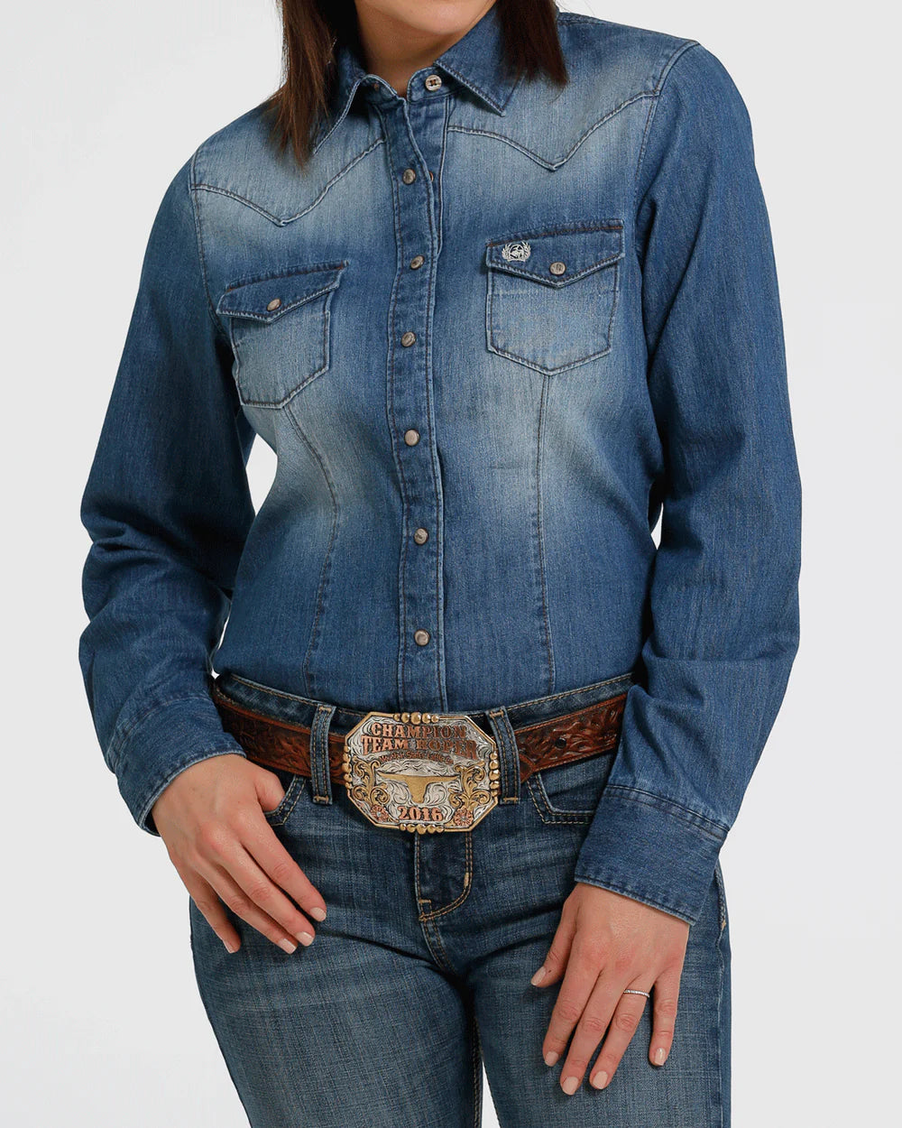 Person wearing a blue denim shirt and jeans with a belt on a white background