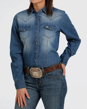 Person wearing a blue denim shirt and jeans with a belt on a white background