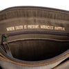 Brown leather bag with a visible brand logo worn by a person.