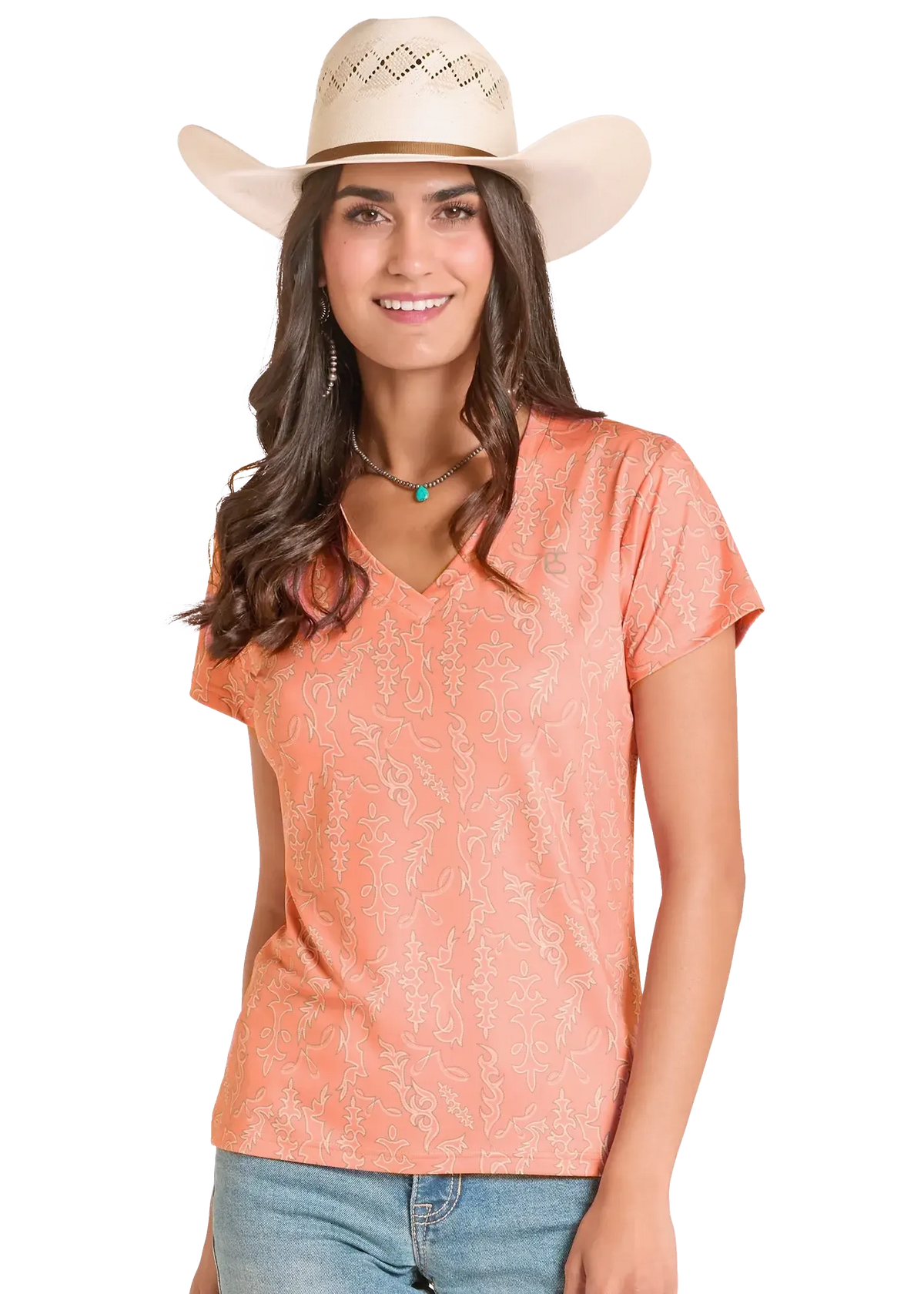 Woman wearing a peach-colored top and beige cowboy hat on a white background