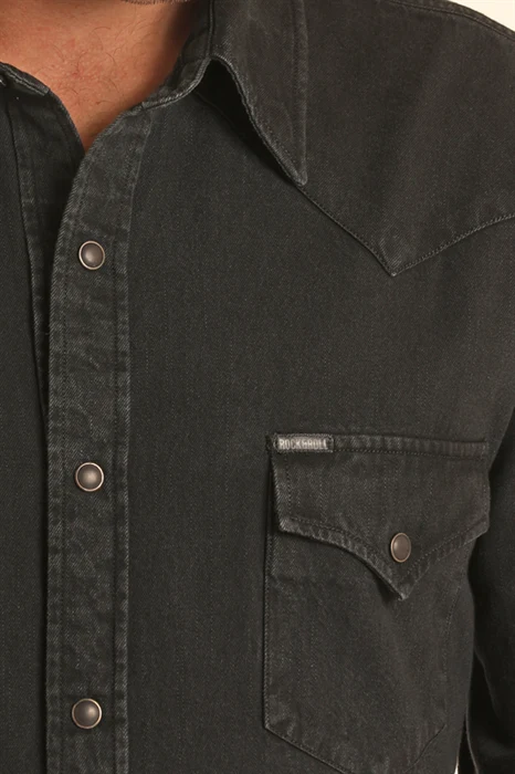 A man wearing a black western long-sleeve snap-down shirt
