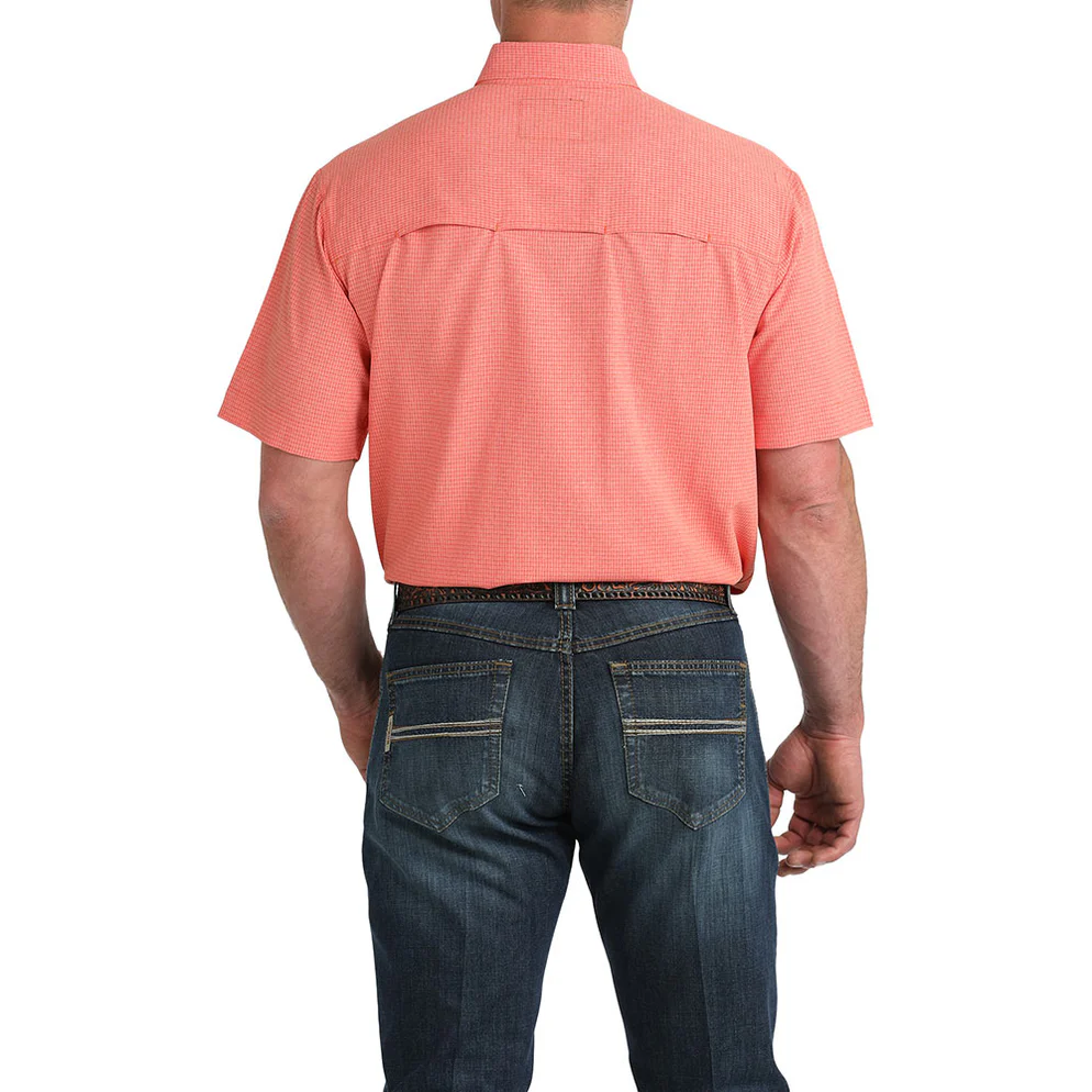 Man wearing a red short-sleeve shirt and blue jeans on a white background