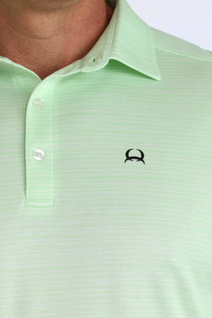 Close-up of a light green polo shirt with a small logo on the chest.