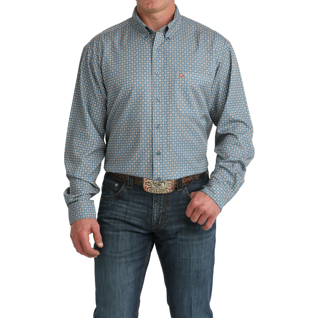 Man wearing a patterned button-up shirt and jeans on a white background