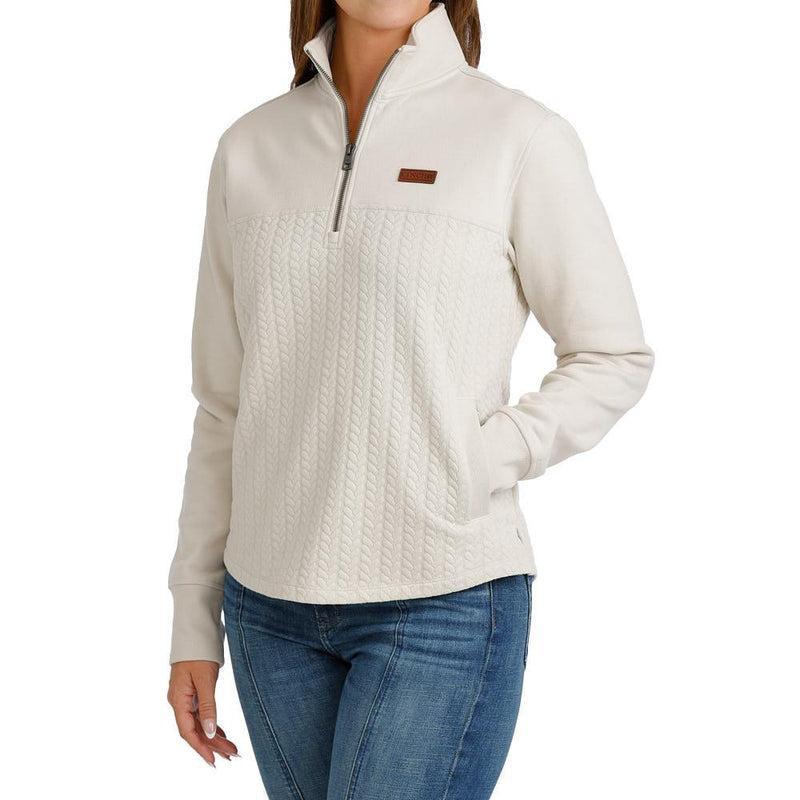 A cream-colored quarter-zip pullover sweater with a textured knit pattern on the front and a small brown logo patch on the chest.