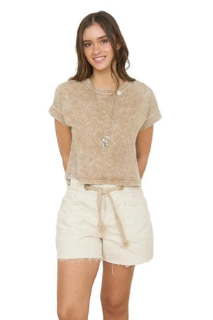 Woman wearing a brown short sleeve top.