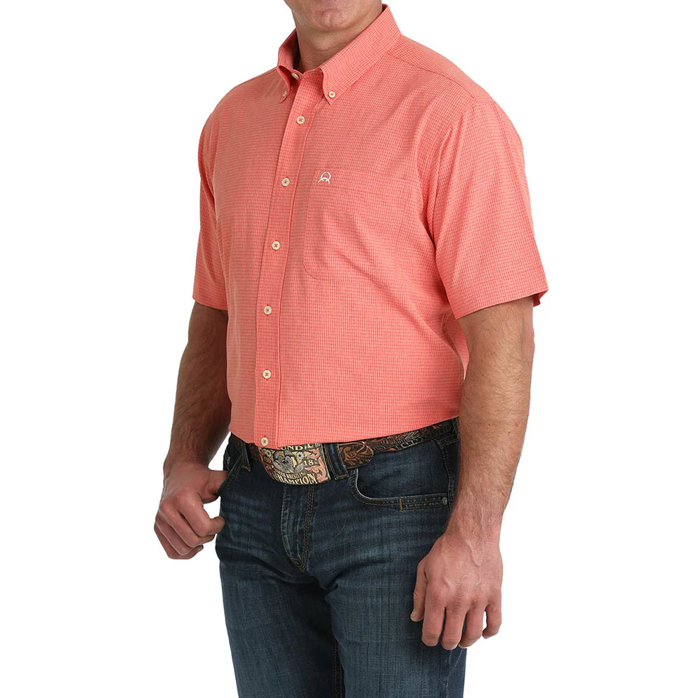 Man wearing a red short-sleeve shirt and blue jeans on a white background