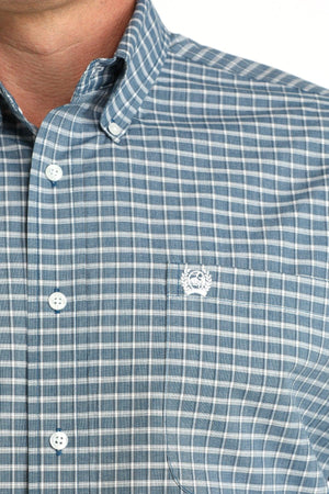 Close-up of a blue checkered shirt with a logo on the chest.