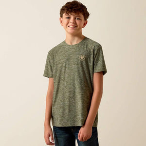 Young boy wearing a green t-shirt with a logo on a beige background