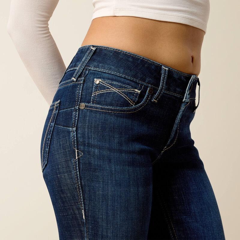 Person wearing blue jeans on a plain background