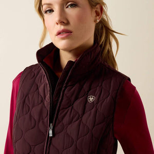 A woman modeling a dark plum quilted zip-front vest