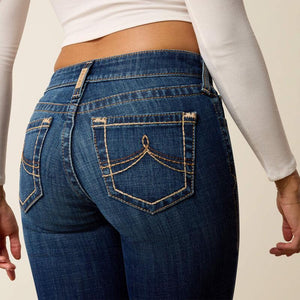 Person wearing blue jeans with a plain background