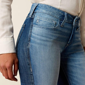 Close-up of blue jeans worn by a person with a neutral background