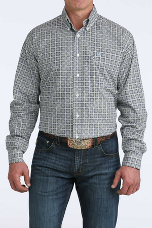 Man wearing a patterned shirt and jeans on a white background