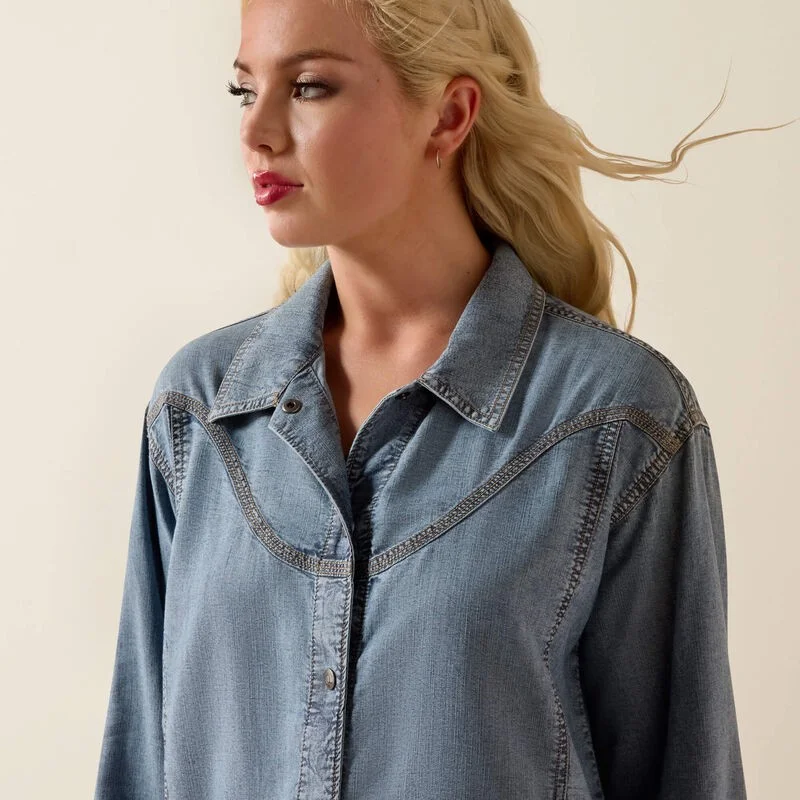 Woman wearing a denim shirt against a beige background