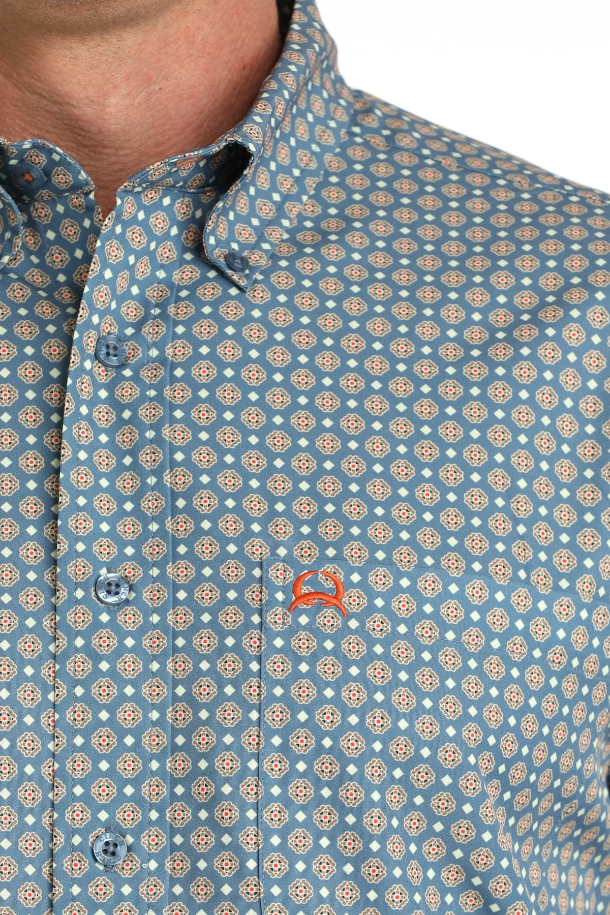 Close-up of a patterned shirt with a small logo on a white background