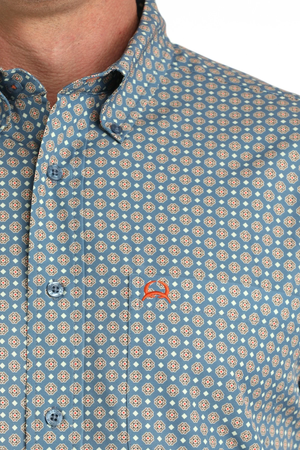 Close-up of a patterned shirt with a small logo on a white background