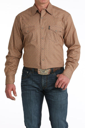 Man wearing a brown patterned shirt and blue jeans on a white background