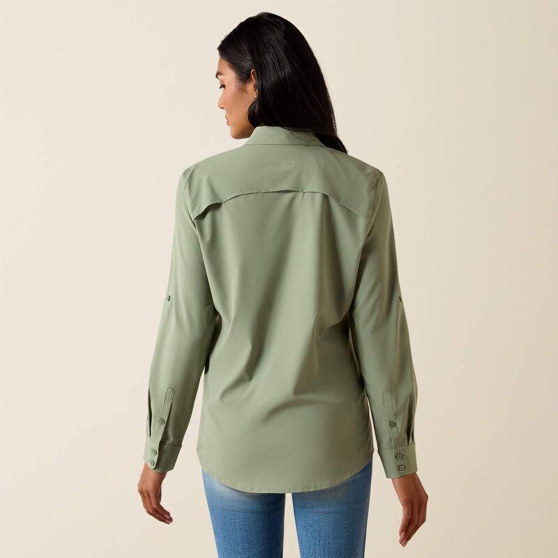 Woman wearing a green shirt and blue jeans on a beige background