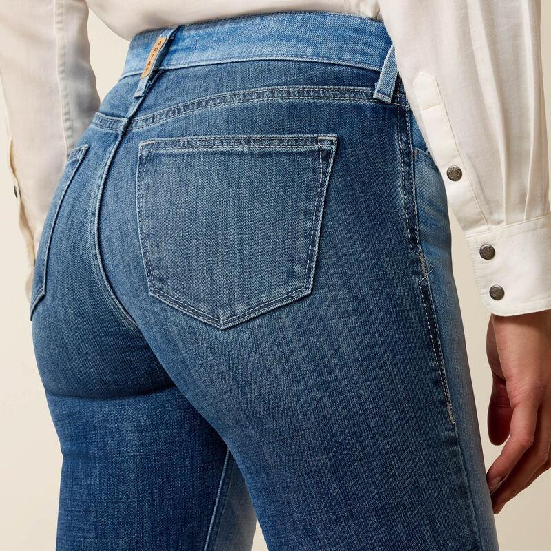 Close-up of blue jeans with a beige background