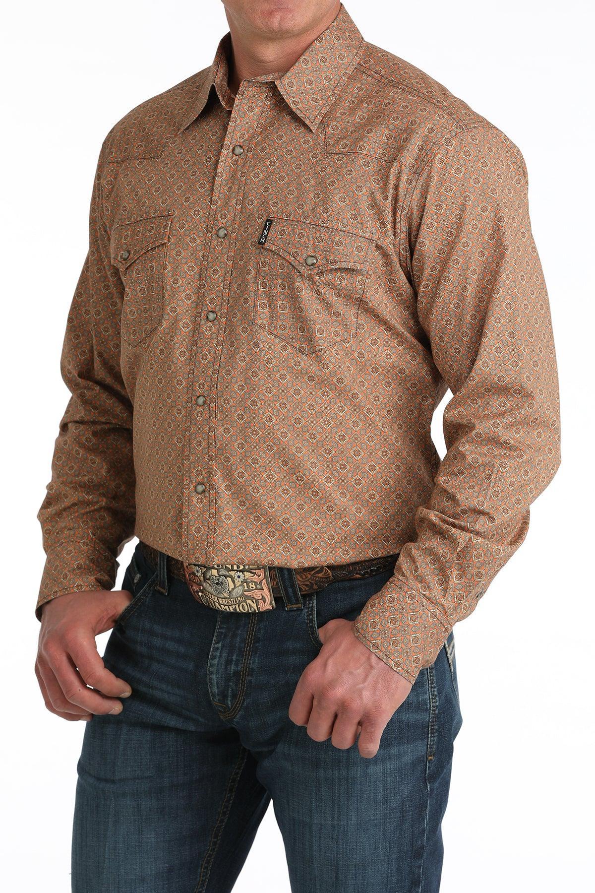 Man wearing a brown patterned long-sleeve shirt and blue jeans on a white background