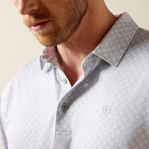 Close-up of a man wearing a light gray patterned shirt with a collar.