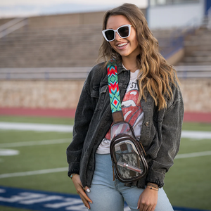 Woman with sunglasses and a colorful bag strap on a sports field