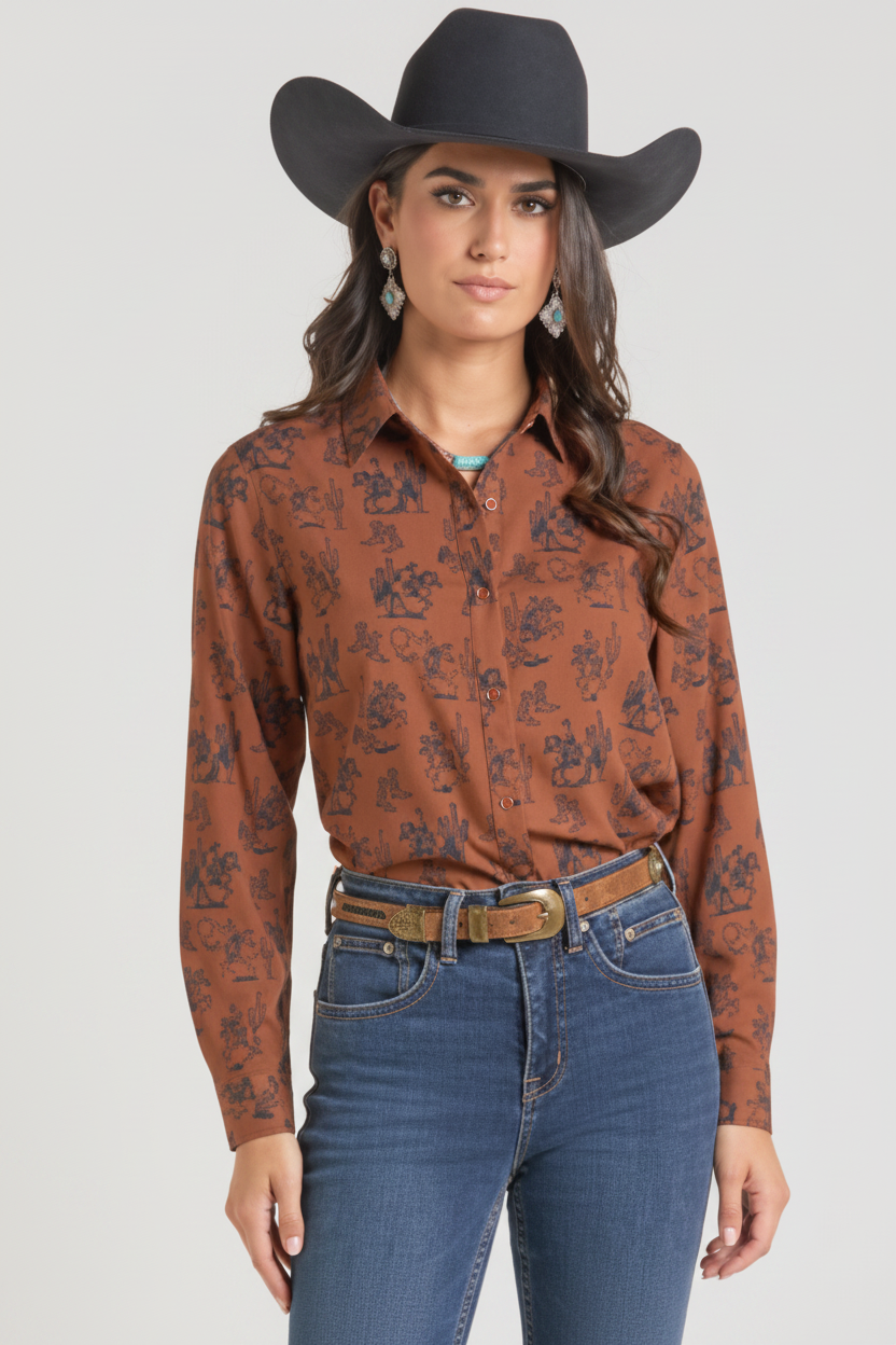 A woman modeling a long-sleeve western-style button-up shirt in rust brown with a black floral pattern, paired with blue jeans and a brown belt, and wearing a black cowboy hat against a plain white background.