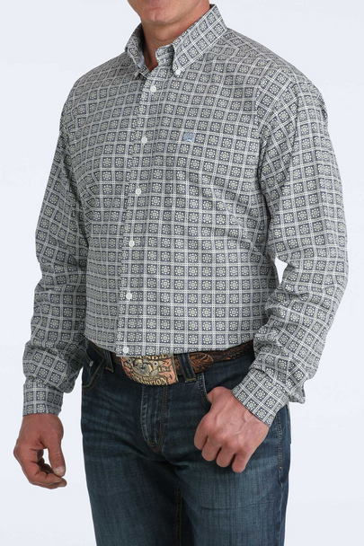 Man wearing a patterned shirt and jeans on a white background
