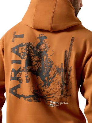 Close-up back view of a person wearing a burnt orange hoodie with a large black western graphic featuring the word ARIAT, a cowboy on a bucking horse, and cacti. The brand text 'Quality Goods Made to Life' is visible near the lower right of the graphic.