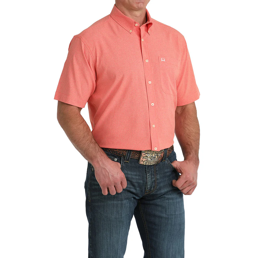Man wearing a red short-sleeve shirt and blue jeans on a white background