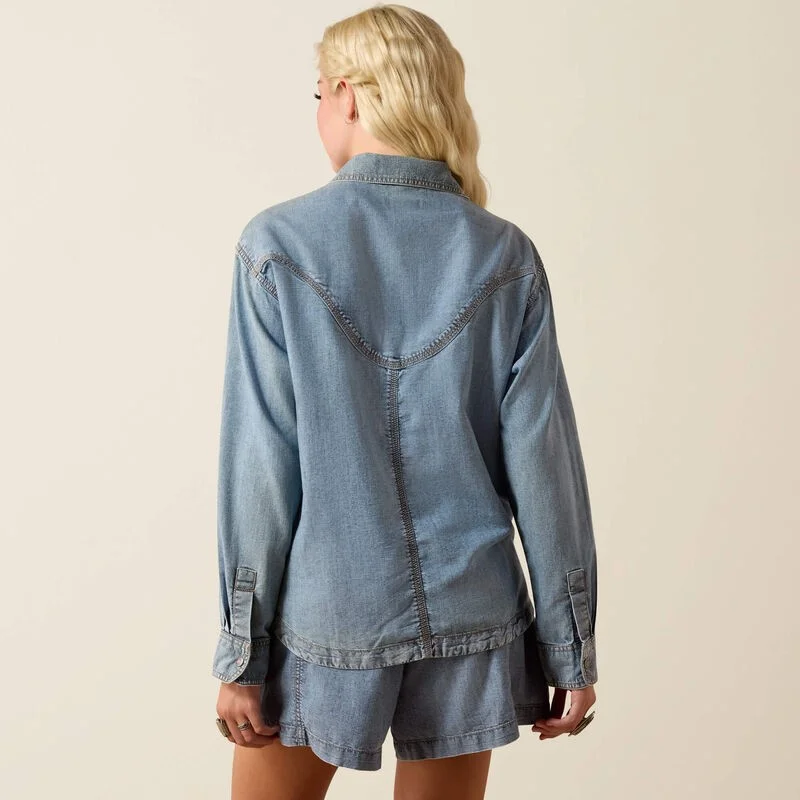 Woman wearing a denim shirt against a beige background