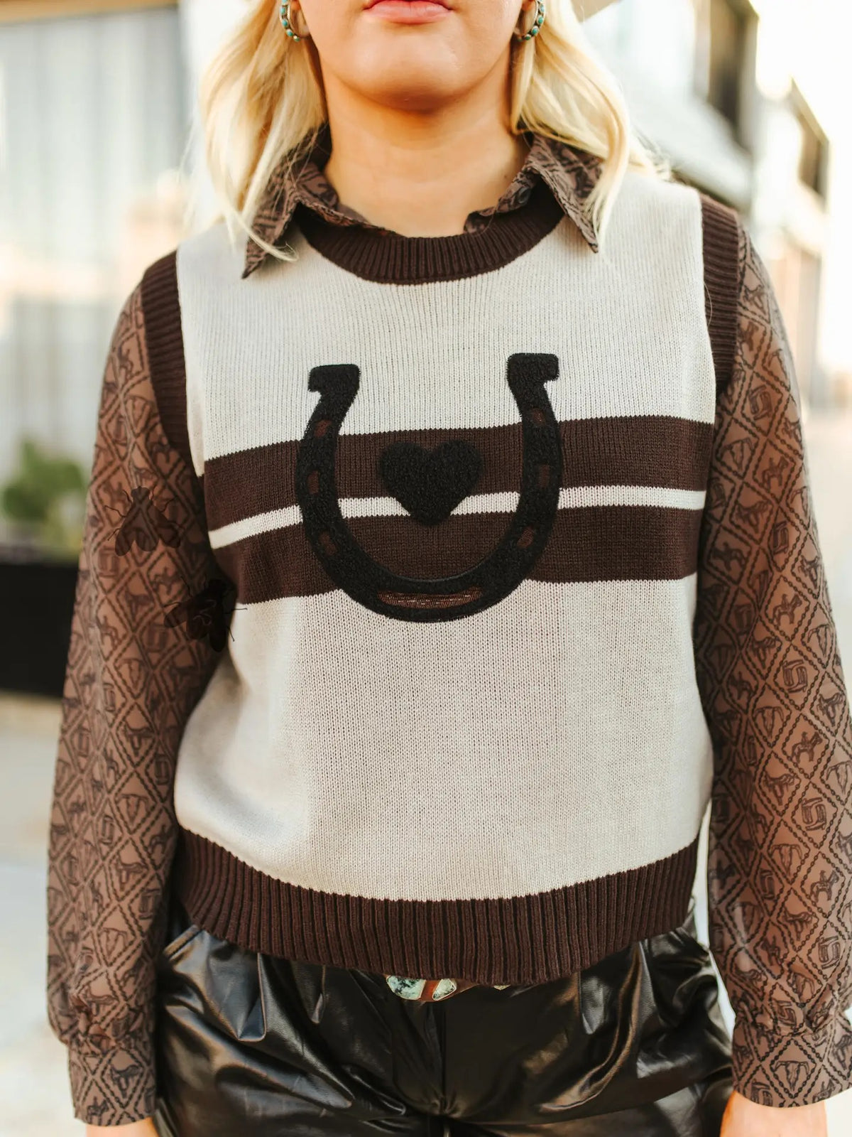 Women’s sweater vest with heart and horseshoe on front.