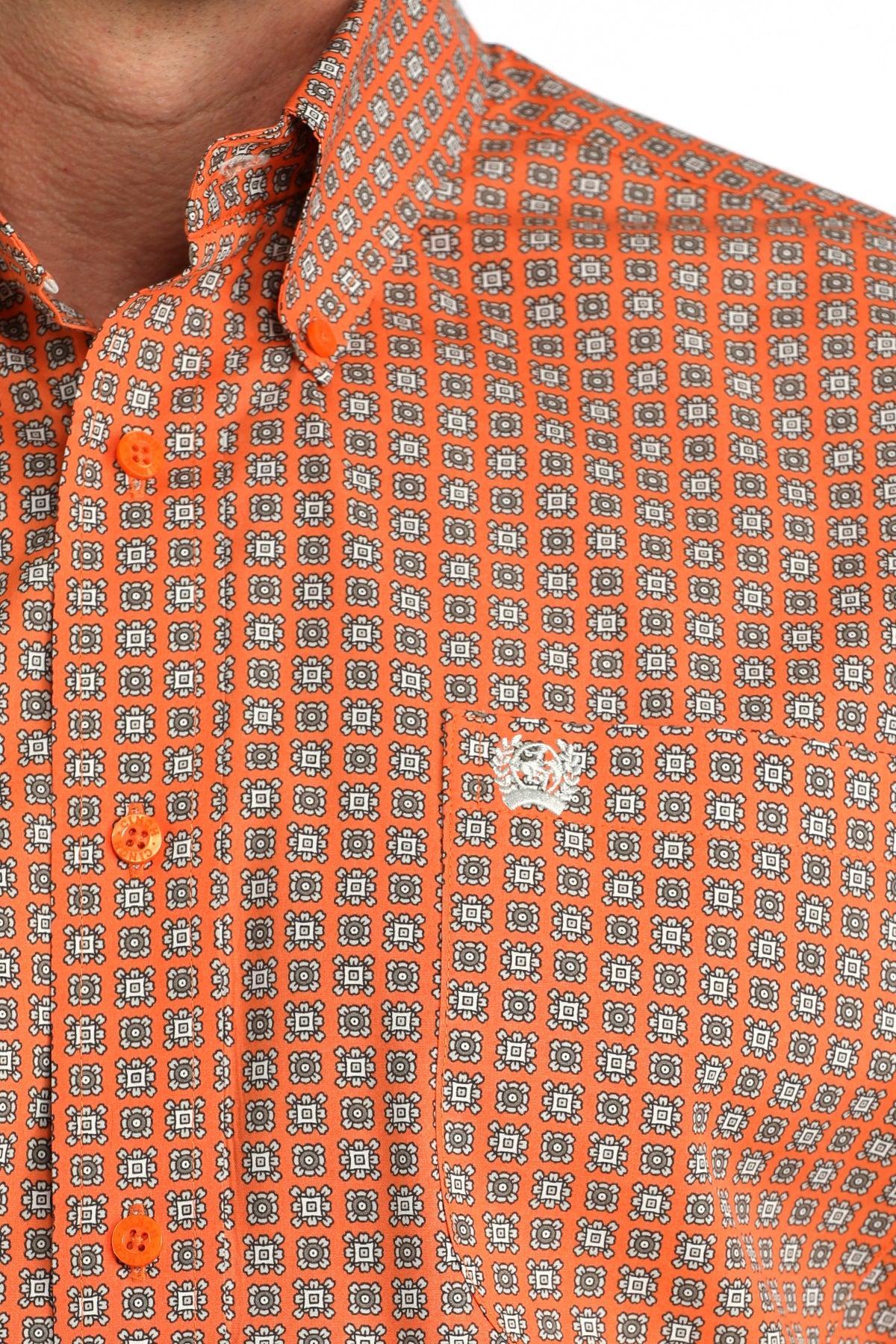 Close-up of an orange patterned shirt with a focus on the collar and buttons.
