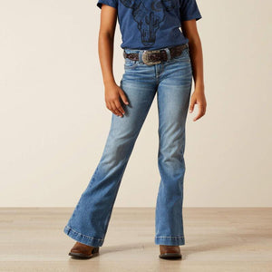 Person wearing blue jeans and a blue shirt with a belt on a beige background