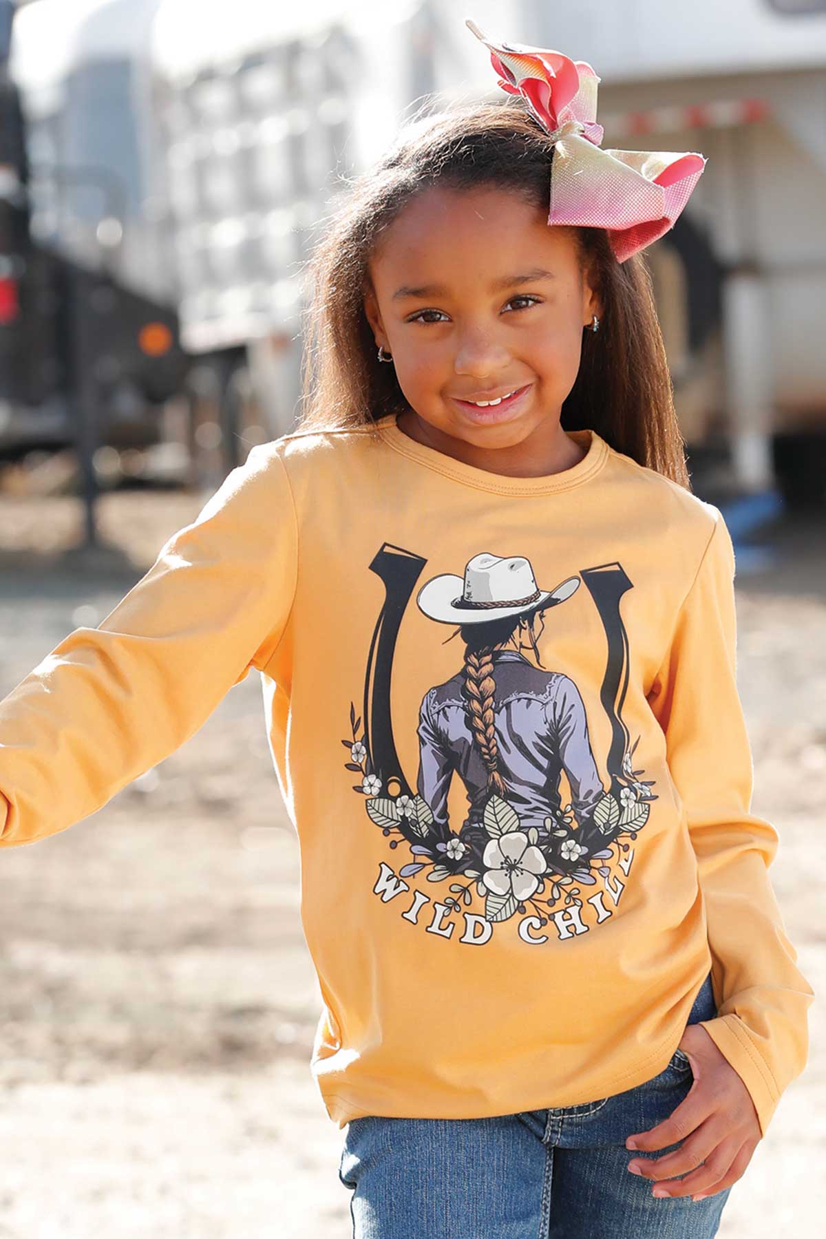 Young girls mustard yellow long-sleeve shirt with a "wild child"graphic design