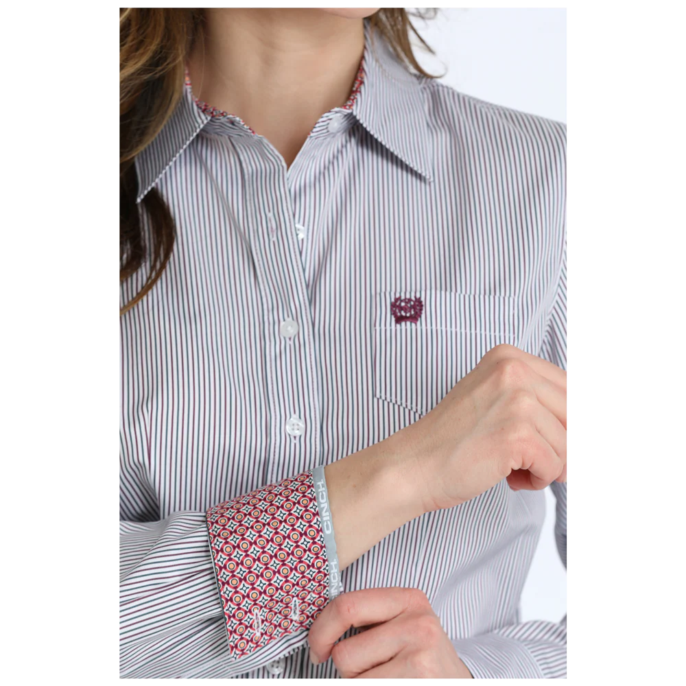 Close-up of a person wearing a striped shirt with patterned cuffs.