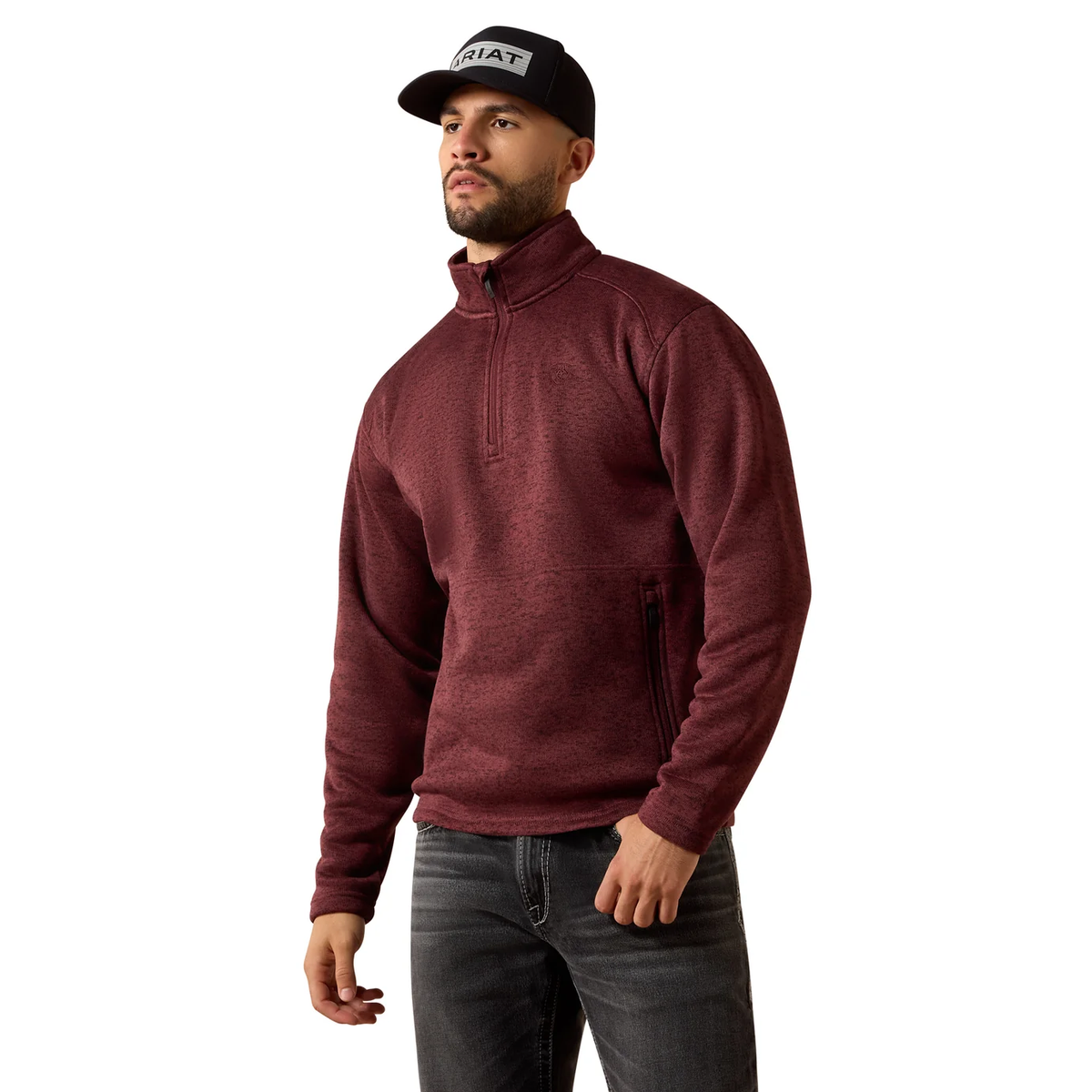 Man wearing a maroon pullover, black cap, and jeans on a white background