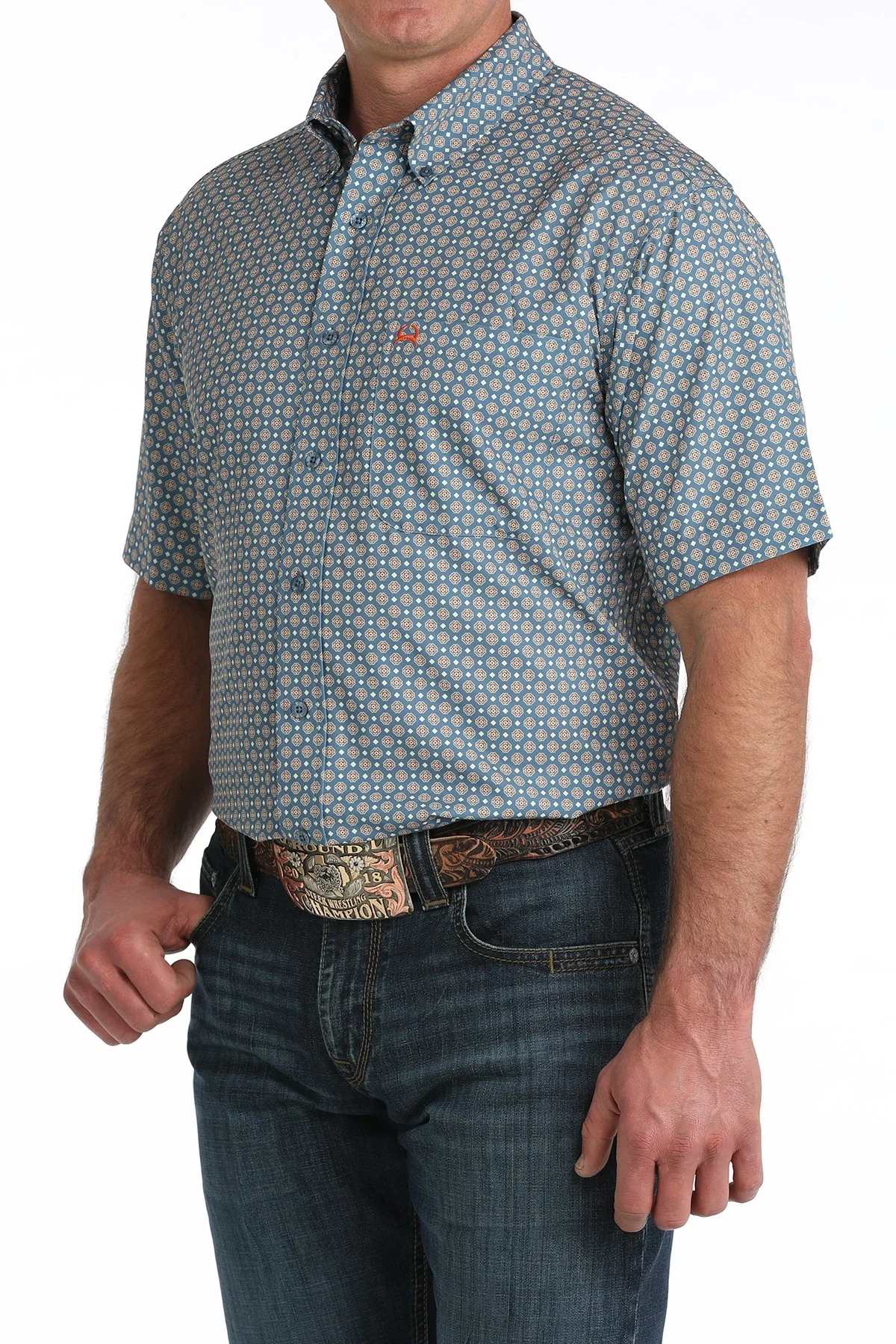 Man wearing a patterned short-sleeve shirt and jeans on a white background